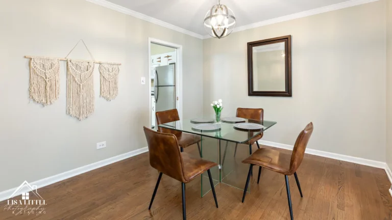 The formal dining room includes a modern glass table, dimmable chandelier and a large picture window.
