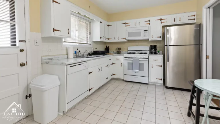 The kitchen offers ample storage, a stainless steel refrigerator, and dishes, pots, pans and housewares galore.